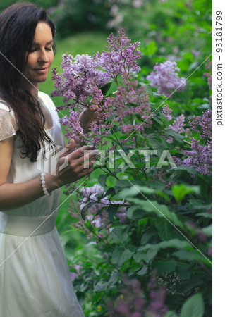 Portrait of an attractive woman surrounded by lilac bushes. Spring and summer, seasonal photos. Vertical photo. Portrait of an attractive woman surrounded by lilac bushes. Spring and summer, seasonal photos. Vertical photo. 93181799