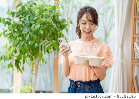 Young woman with lunch and smartphone Young woman with lunch and smartphone 93182180