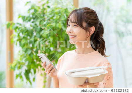 Young woman with lunch and smartphone Young woman with lunch and smartphone 93182182