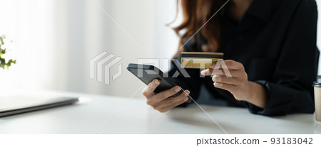 Close up of woman hold bank credit card shopping online using mobile phone, buying goods or ordering online, entering bank accounts and details in online banking offer. Close up of woman hold bank credit card shopping online using mobile phone, buying goods or ordering online, entering bank accounts and details in online banking offer. 93183042