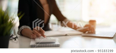 Close up a accountant working about financial with calculator and laptop computer at office to calculate expenses, Accounting concept 93183199