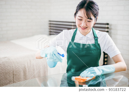 Housekeeper woman wiping the table Housekeeper woman wiping the table 93183722