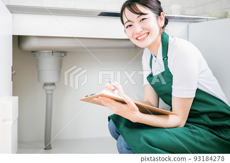 Female checking the water supply (under the sink) Female checking the water supply (under the sink) 93184278