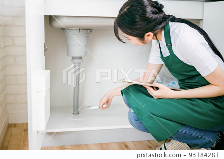 Female checking the water supply (under the sink) 93184281