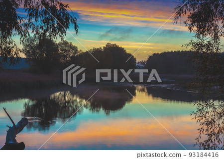 Rural nature landscape. Sunset over the lake. Magic colorful sunset in the countryside. Rural landscape in the evening. Beautiful summer nature 93184416