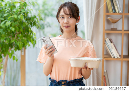 Young woman with lunch and smartphone Young woman with lunch and smartphone 93184637
