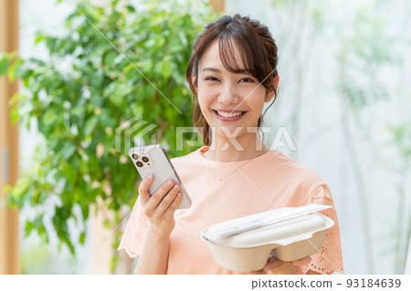 Young woman with lunch and smartphone Young woman with lunch and smartphone 93184639