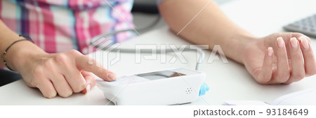 Woman measuring blood pressure with electric digital tonometer closeup 93184649