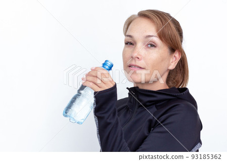 Woman holding plastic bottle of water on white background Woman holding plastic bottle of water on white background 93185362