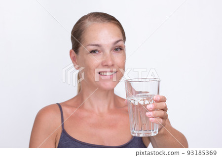 Woman of40s holding glass of pure water Woman of40s holding glass of pure water 93185369