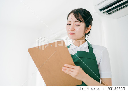 Female checking the air conditioner (problem) Female checking the air conditioner (problem) 93186235