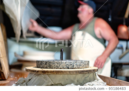 Pressure to create typical cheese form of Bergamo mountains in northern Italy 93186483