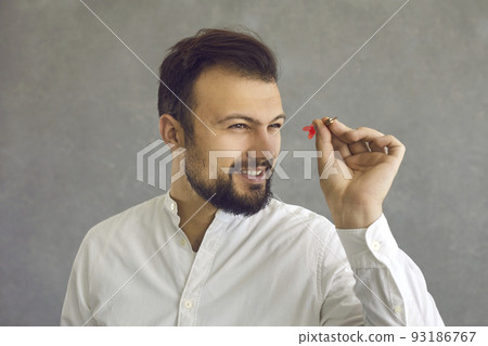 Portrait of a confident successful young businessman aiming a dart arrow at a target 93186767