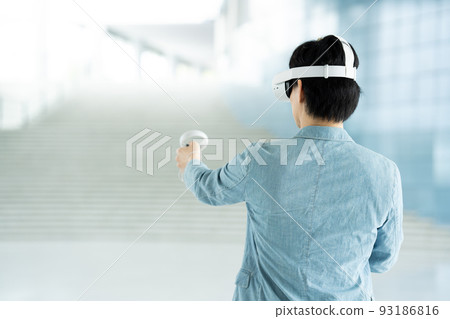 Back view of a man experiencing virtual reality with VR Back view of a man experiencing virtual reality with VR 93186816