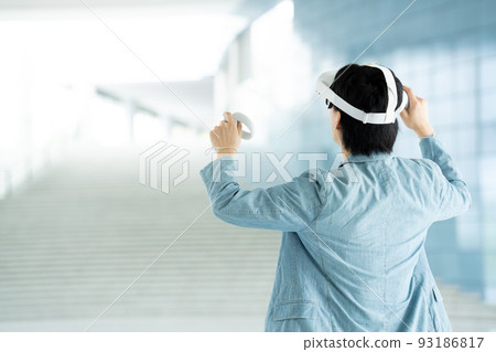 Back view of a man experiencing virtual reality with VR Back view of a man experiencing virtual reality with VR 93186817