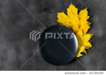 Autumn table setting with bright colorful leaves and black plate. Flat lay. Autumn table setting with bright colorful leaves and black plate. Flat lay. 93188280