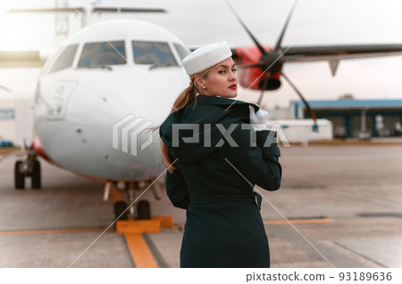 Back view of flight attendant looking away on background of aircraft. Ready to flight 93189636