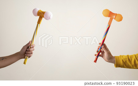 Hands with toy hammers against light background 93190023