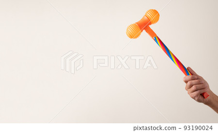 toy hammer in hand against light background toy hammer in hand against light background 93190024