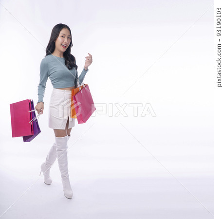 Enjoyment excited asian woman carry shoppingbags standing full body on white background.Trendy happy 93190103