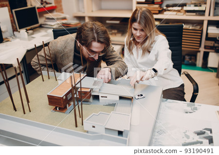 Architect with blueprints and layout design project at office bureau 93190491