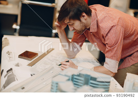 Architect with blueprints and layout design project at office bureau 93190492