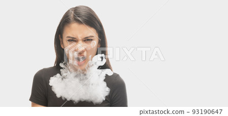 Angry young girl with dark hair releases smoke from the mouth isolated over white background. Concept of mental health, art, human emotions 93190647