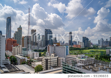 Aerial view of Bangkok cityscape in the morning showing high-rises with a golf course and cloudy blue sky 93190833