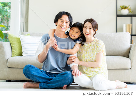 一個在客廳裡放鬆的年輕家庭 93191167