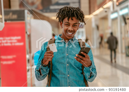 Happy guy showing ticket to camera standing at station Happy guy showing ticket to camera standing at station 93191480