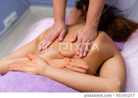 Top view of hands massaging female abdomen.Therapist applying pressure on belly. Woman receiving massage at spa salon 93193257
