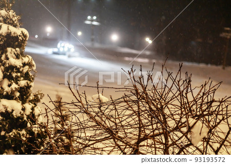 Ski slope preparation machine with headlights on in snowy mountains. Snowcat preparing a slope at night. Selective focus Ski slope preparation machine with headlights on in snowy mountains. Snowcat preparing a slope at night. Selective focus 93193572