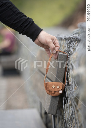 Someone lost a bag. A man 's hand takes a found lost thing - a small children 's women 's handbag . Abandoned or abandoned items, lost and found Someone lost a bag. A man 's hand takes a found lost thing - a small children 's women 's handbag . Abandoned or abandoned items, lost and found 93194060
