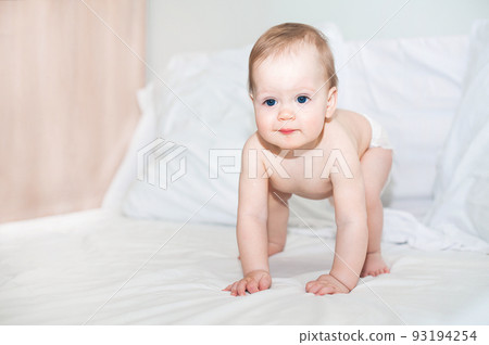 Baby in diaper on bed close-up. Infant learns to crawl.. 93194254