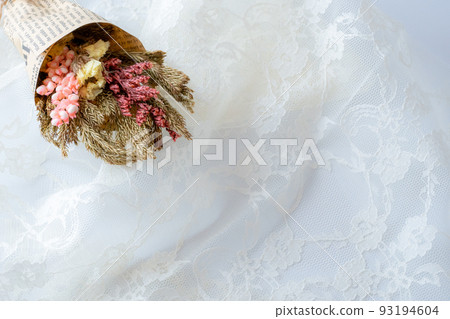 Bouquet of dried pink flowers placed on the upper left of the white lace Bouquet of dried pink flowers placed on the upper left of the white lace 93194604