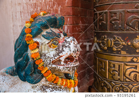 A statue and prayer wheel in the square of Boudhanath, the largest pagoda in Nepal in Kathmandu, Nepal 93195261