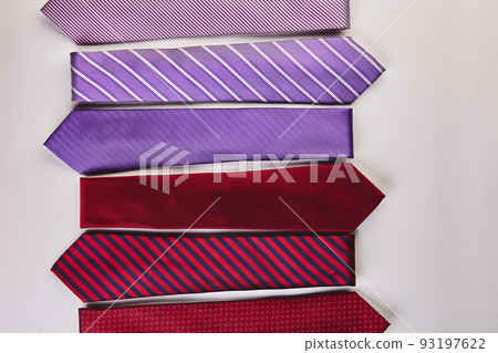 Red and purple ties of different patterns on white background 93197622