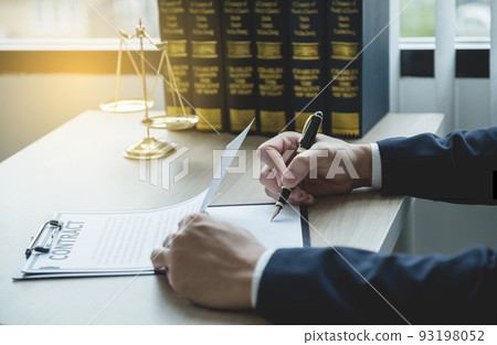 Lawyer hand holding pen and providing legal consult business dispute service at the office with justice scale and gavel hammer 93198052