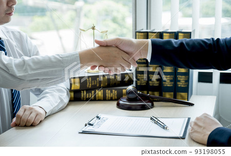 Handshake after Lawyer  providing legal consult business dispute service to the man at the office with justice scale and gavel hammer 93198055