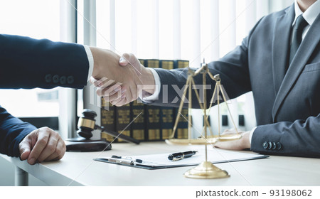 Handshake after Lawyer  providing legal consult business dispute service to the man at the office with justice scale and gavel hammer 93198062