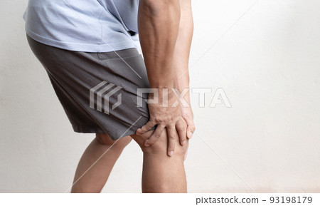 man hand massage physiotherapy her knee is sore and numb, exhausted, tingling. Guillain-Barre Syndrome, a side effect of the Covid vaccination 93198179