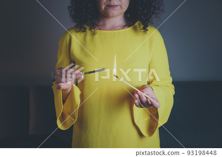 Close-up of adult woman lights up with matches and smoking medical marijuana joint. 93198448