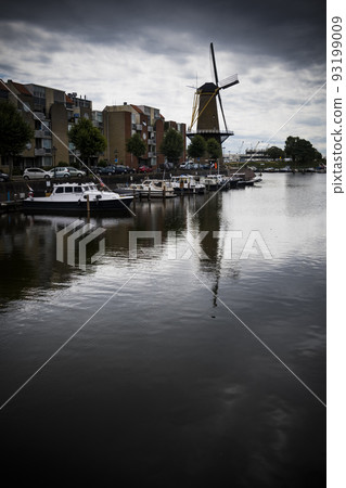 Vintage windmill across the water in Delfshaven district of Rotterdam 93199009
