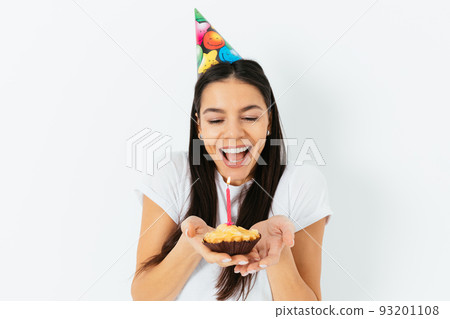 Portrait of happy young woman in party cap smiling 93201108