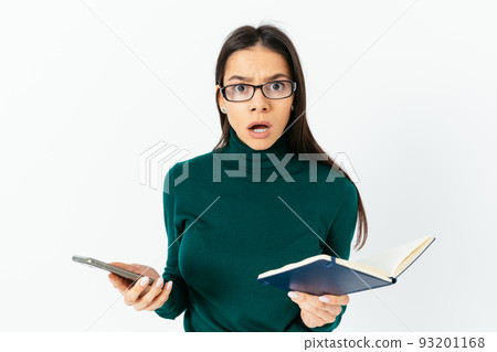 Confused young woman wearing glasses looks in surprise 93201168