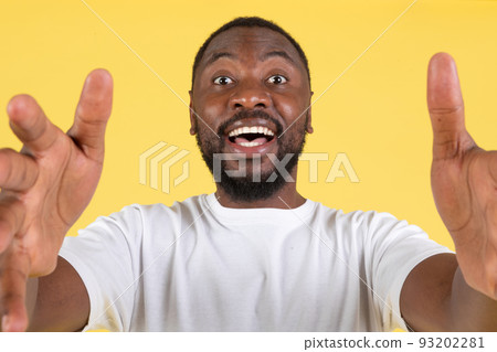 Excited Black Guy Stretching Hands To Camera Over Yellow Background Excited Black Guy Stretching Hands To Camera Over Yellow Background 93202281