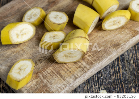 not peeled ripe yellow banana cut into pieces on a board not peeled ripe yellow banana cut into pieces on a board 93203156