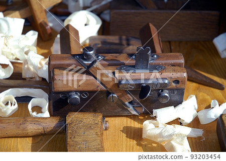 Chisel and small block plane with wood shavings. Carpenter cabinet maker hand tools on the workbench. 93203454