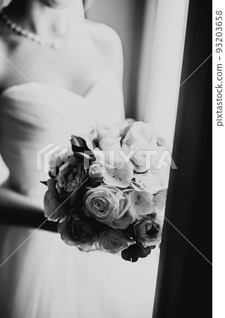 Bride holding big and beautiful wedding bouquet with flowers Bride holding big and beautiful wedding bouquet with flowers 93203658