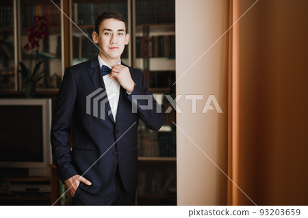 Grooms morning preparation. Handsome man getting dressed and preparing for the wedding Grooms morning preparation. Handsome man getting dressed and preparing for the wedding 93203659